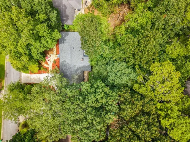 an aerial view of a house with a yard and large trees