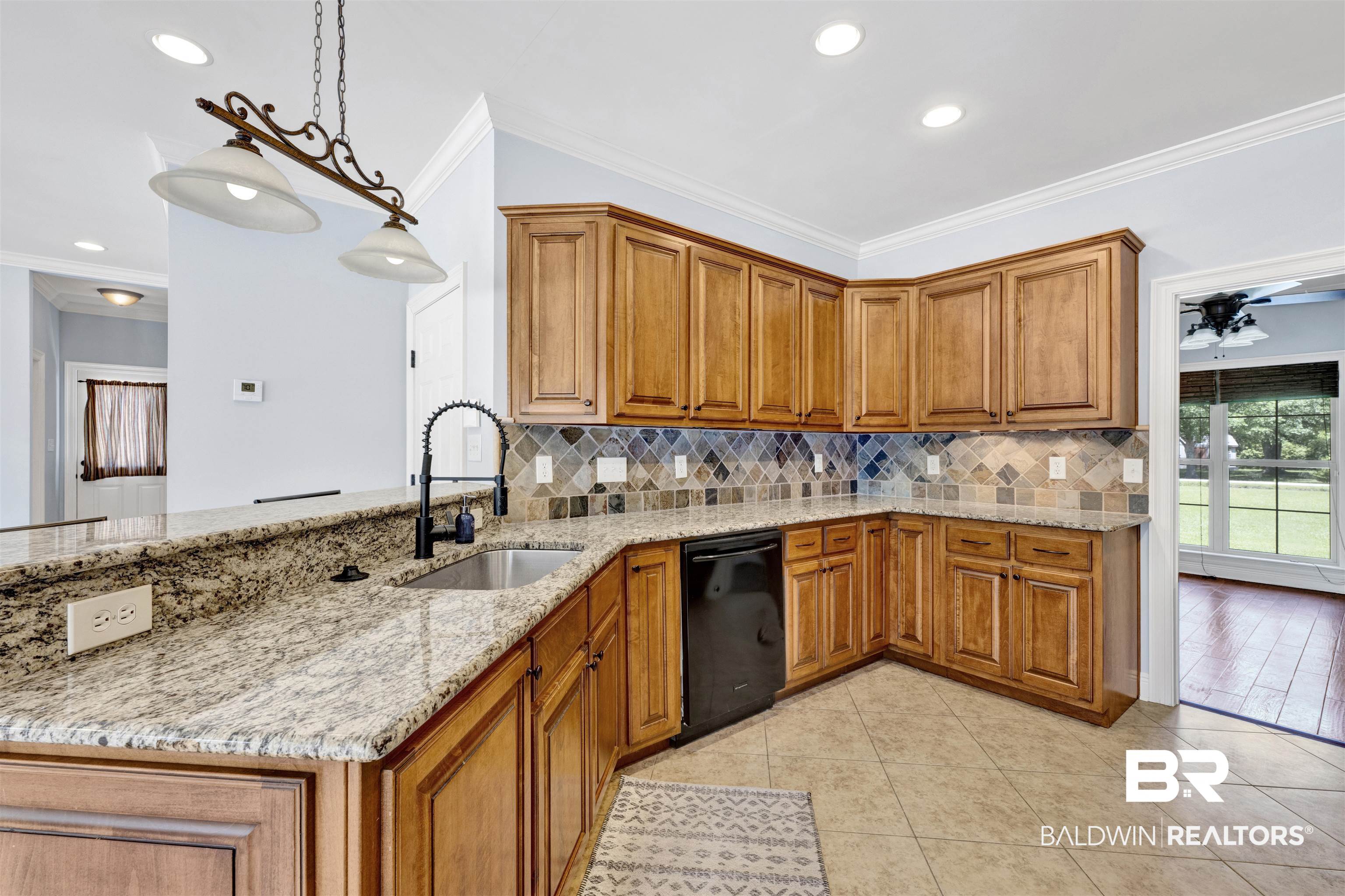 12944 Anna's Way Stapleton, AL 36578 - Photo 43 of 64 Kitchen featuring granite countertops, wood cabinetry, a tile backsplash, and a black built-in dishwasher