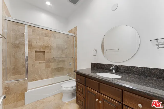 an empty room with wooden floor and fan