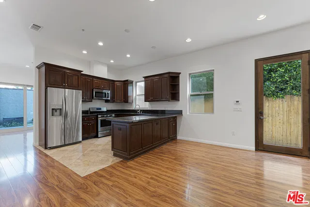 a kitchen with stainless steel appliances granite countertop a refrigerator stove top oven and sink