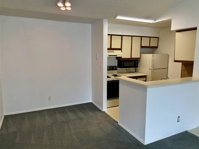 a kitchen with a refrigerator stove and white cabinets