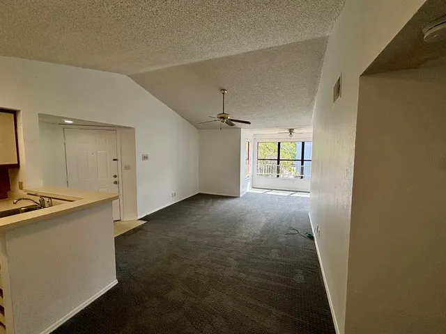 a view of a kitchen with refrigerator and wooden floor