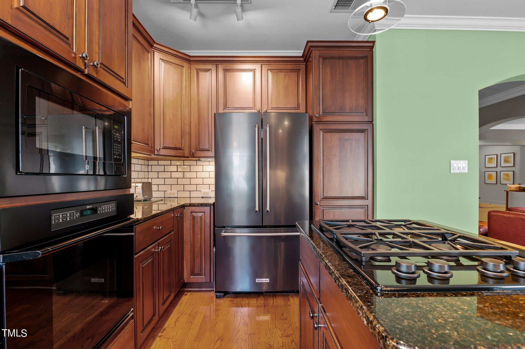 3700 Baron Cooper Pass, Unit 202 Raleigh, NC 27612 - Photo 25 of 49 a kitchen with wooden cabinets and stainless steel appliances