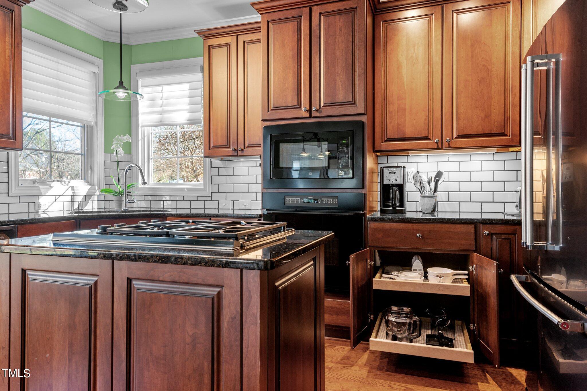 3700 Baron Cooper Pass, Unit 202 Raleigh, NC 27612 - Photo 26 of 49 a kitchen with granite countertop a stove and a wooden cabinets