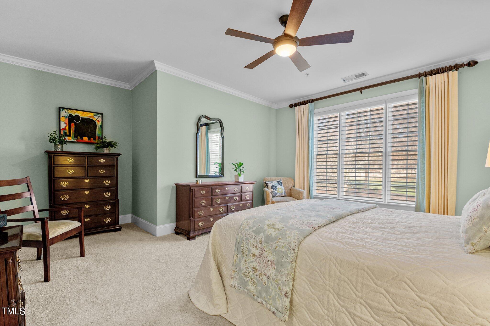 3700 Baron Cooper Pass, Unit 202 Raleigh, NC 27612 - Photo 30 of 49 a bedroom with a bed a dresser and a chandelier