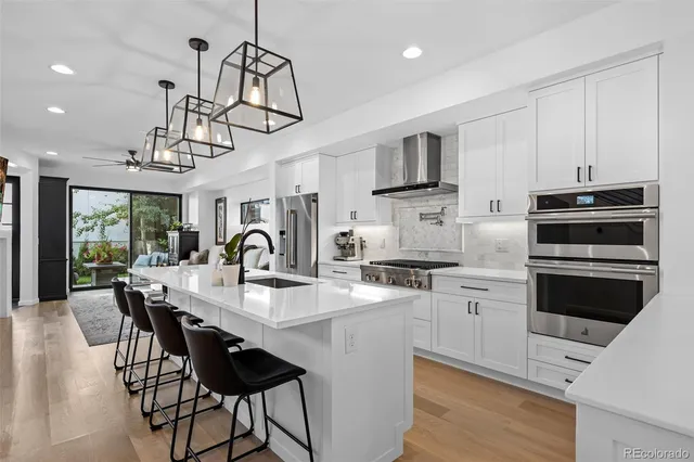 a kitchen with stainless steel appliances a table chairs and refrigerator