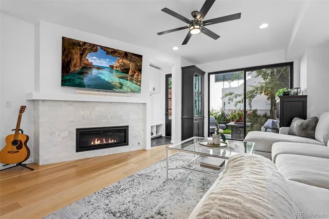 a living room with furniture a floor to ceiling window and a fireplace