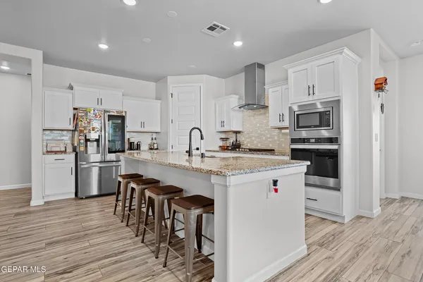 a kitchen with white cabinets and stainless steel appliances