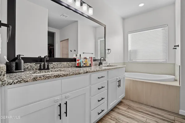 a bathroom with double vanity and a bathtub