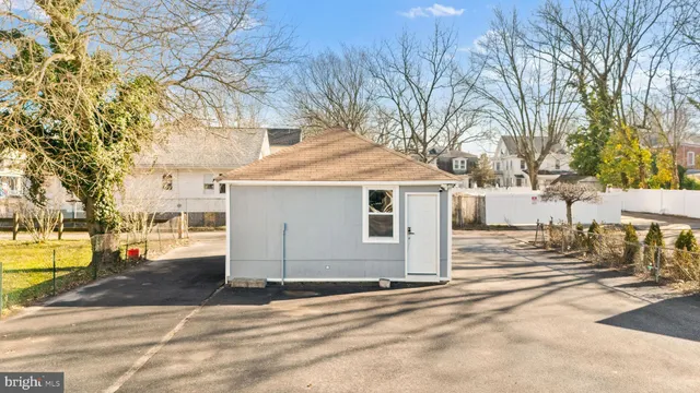 a view of a white house with a large tree