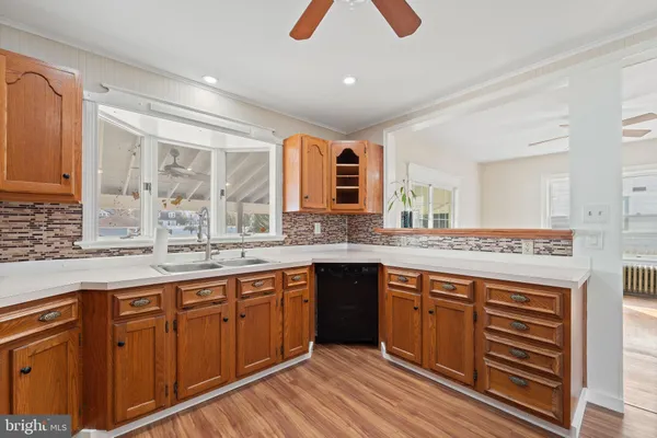 a large kitchen with kitchen island granite countertop wooden cabinets and a sink