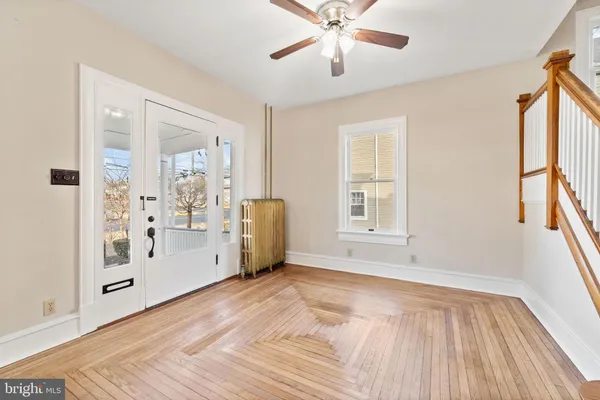 a view of an empty room with window and wooden floor