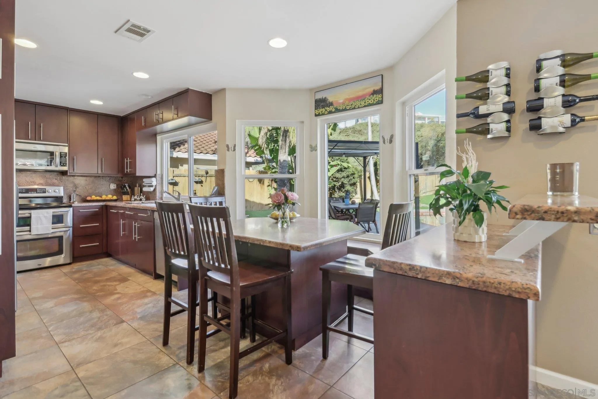 9186 Truman Street San Diego, CA 92129 - Photo 11 of 61 a kitchen with stainless steel appliances granite countertop sink stove and white cabinets