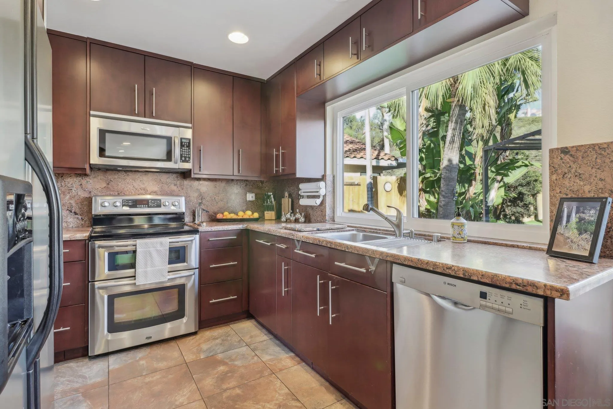9186 Truman Street San Diego, CA 92129 - Photo 13 of 61 a kitchen with kitchen island granite countertop a stove sink and microwave