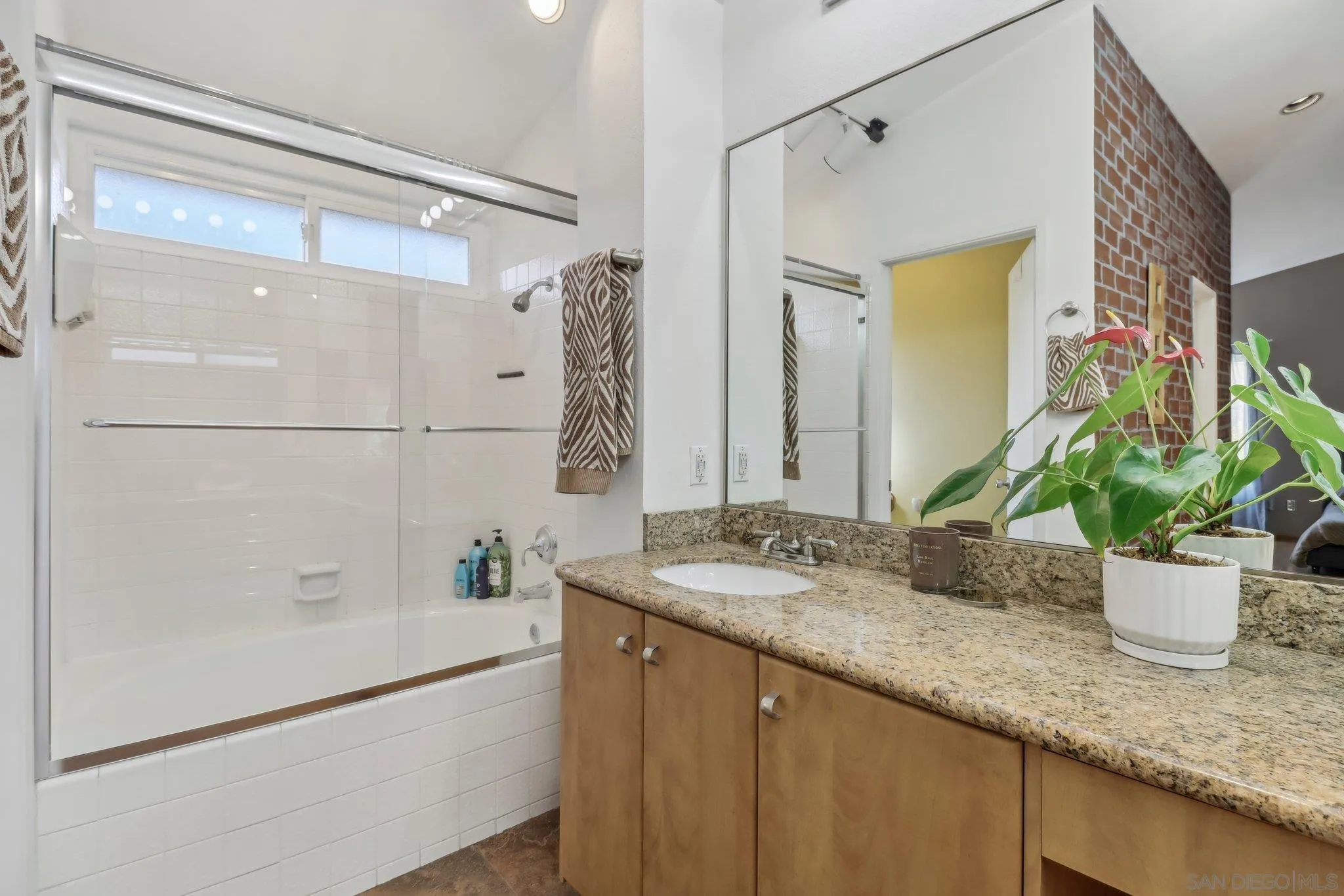9186 Truman Street San Diego, CA 92129 - Photo 34 of 61 a bathroom with a granite countertop sink a mirror and a shower