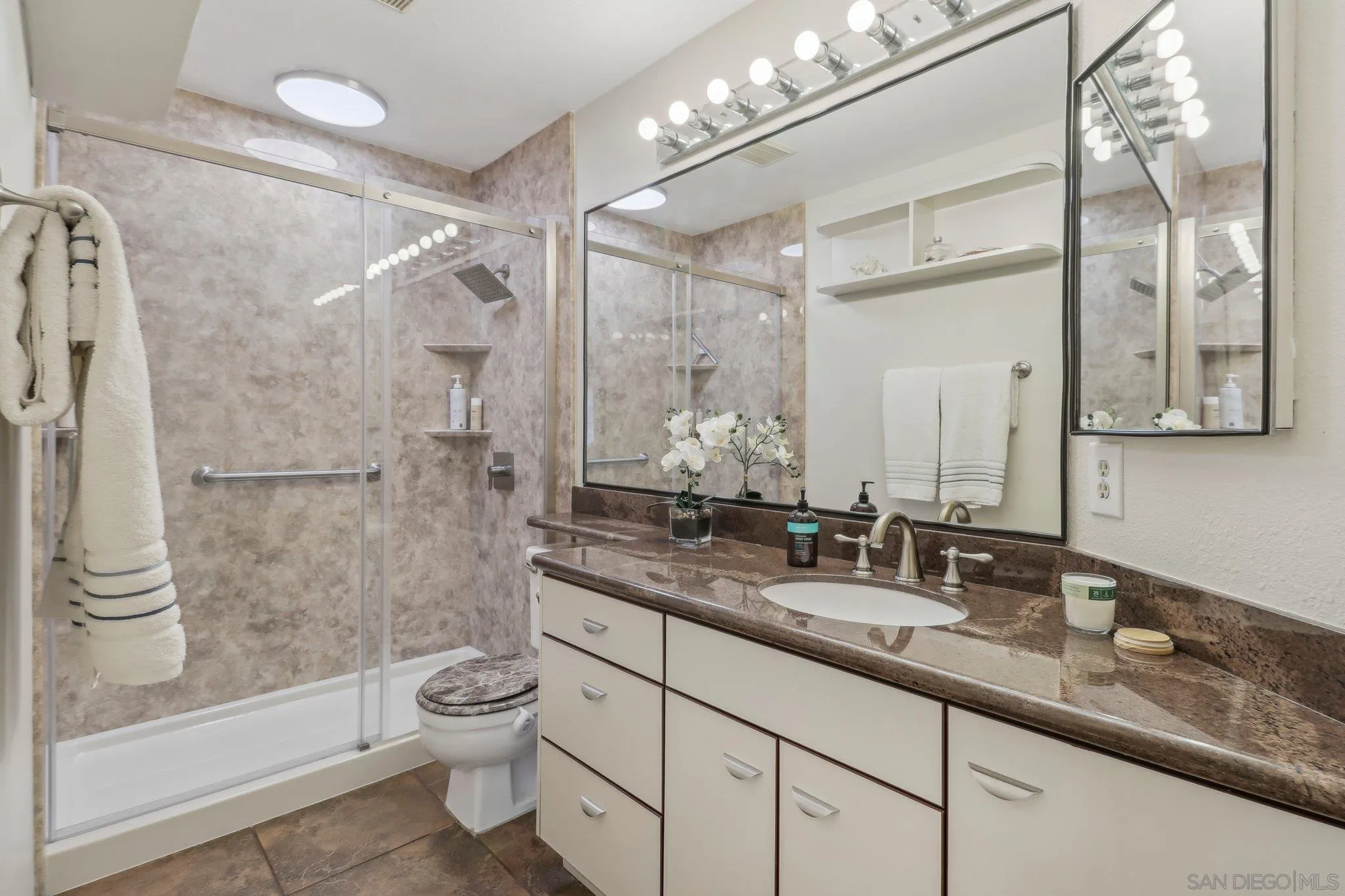 9186 Truman Street San Diego, CA 92129 - Photo 39 of 61 a bathroom with a granite countertop sink a toilet and shower