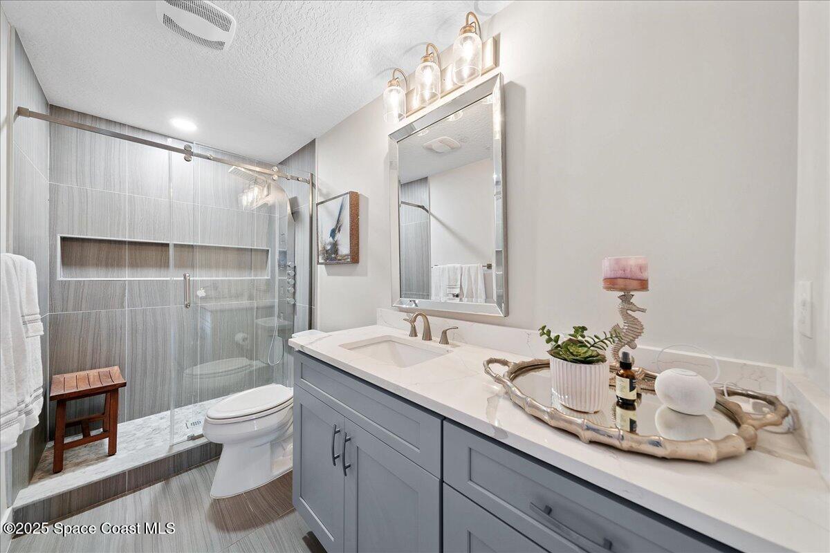 5685 Lake Washington Road Melbourne, FL 32934 - Photo 16 of 63 a bathroom with a double vanity sink toilet and shower