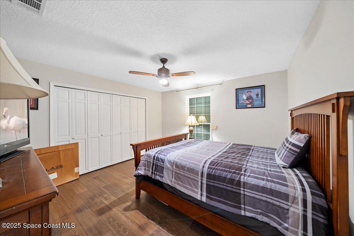5685 Lake Washington Road Melbourne, FL 32934 - Photo 18 of 63 a bedroom with a bed wooden floor and window