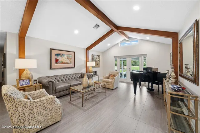 a living room with furniture a wooden floor and a large window