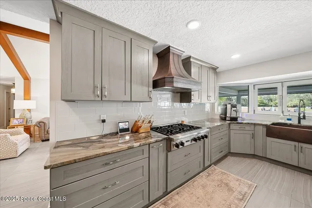 a kitchen with granite countertop a sink stove and refrigerator