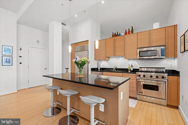 a kitchen with stainless steel appliances granite countertop a stove a sink and a refrigerator