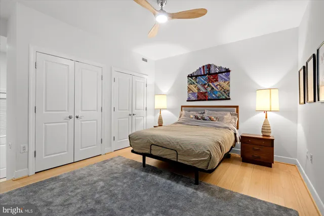 a spacious bedroom with a bed and a painting on the wall