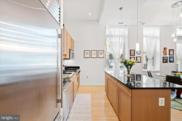 a kitchen with stainless steel appliances granite countertop a refrigerator a stove and a sink