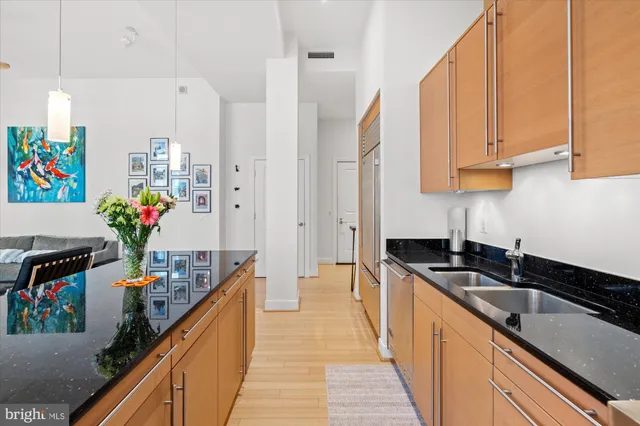 a kitchen filled with stainless steel appliances a sink a counter top space and cabinets
