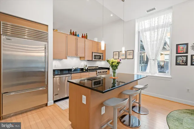a kitchen with granite countertop a refrigerator and a sink
