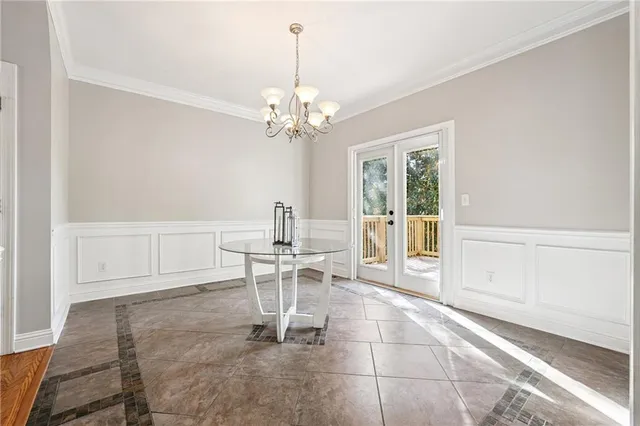 a dining room with wooden floor a chandelier a wooden table and chairs