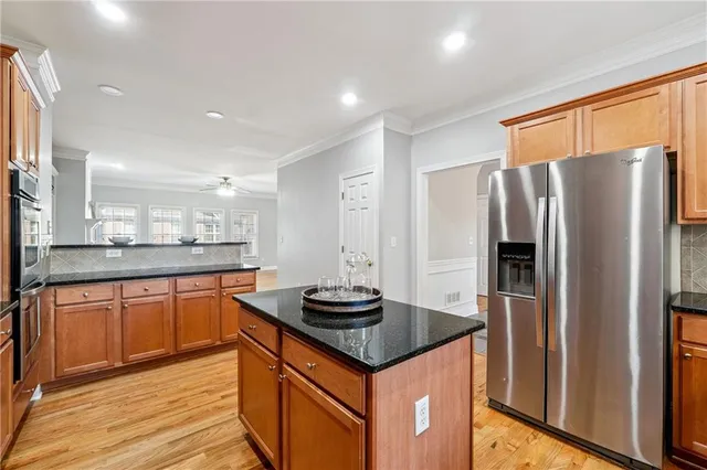 a kitchen with stainless steel appliances granite countertop a refrigerator and a sink