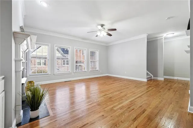 a view of an empty room with window and wooden floor