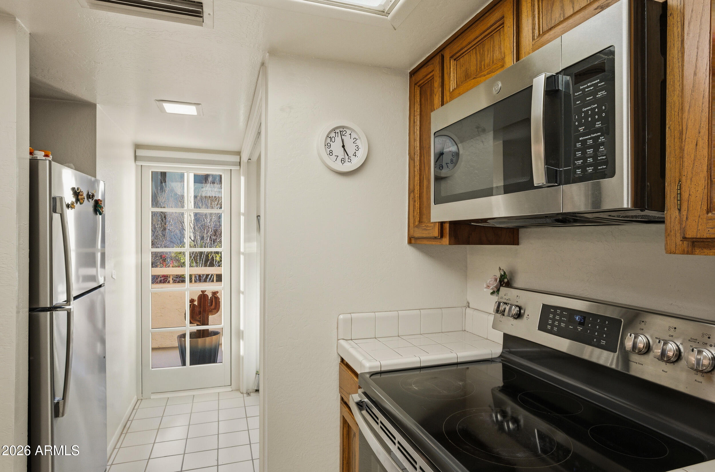 6150 North Scottsdale Road, Unit 52 Paradise Valley, AZ 85253 - Photo 13 of 24 a kitchen with stainless steel appliances granite countertop a stove and a microwave