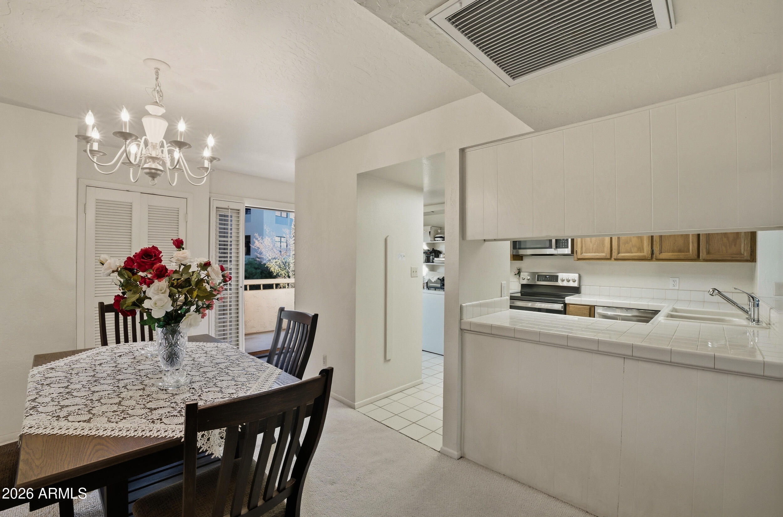 6150 North Scottsdale Road, Unit 52 Paradise Valley, AZ 85253 - Photo 4 of 24 a view of a dining room with furniture and chandelier