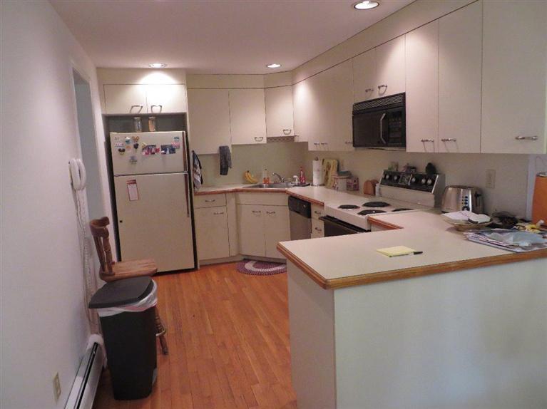 245 Great Marsh Road Centerville, MA 02632 - Photo 8 of 17 a kitchen with a sink a stove a microwave a counter top space and cabinets