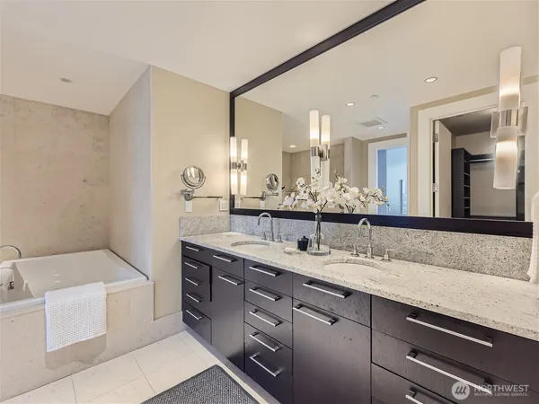 a spacious bathroom with a granite countertop double vanity sink mirror and bathtub