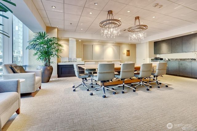 a living room with furniture kitchen view and a large window