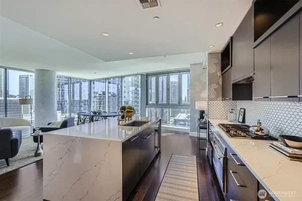 a kitchen with counter top space a sink a stove and a window