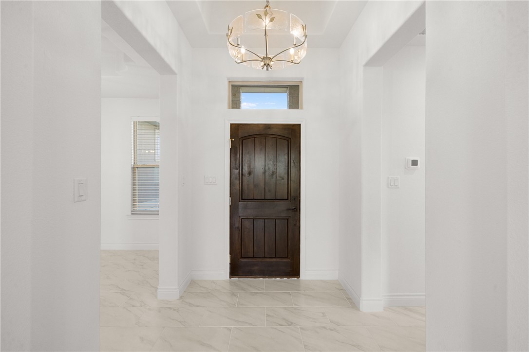 6512 Agave Court Bryan, TX 77808 - Photo 15 of 42 Foyer entrance featuring light marble finish flooring and a chandelier