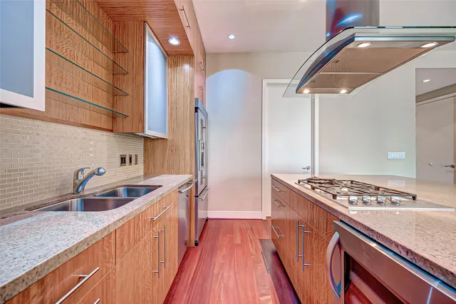 a kitchen with kitchen island stainless steel appliances a sink and refrigerator