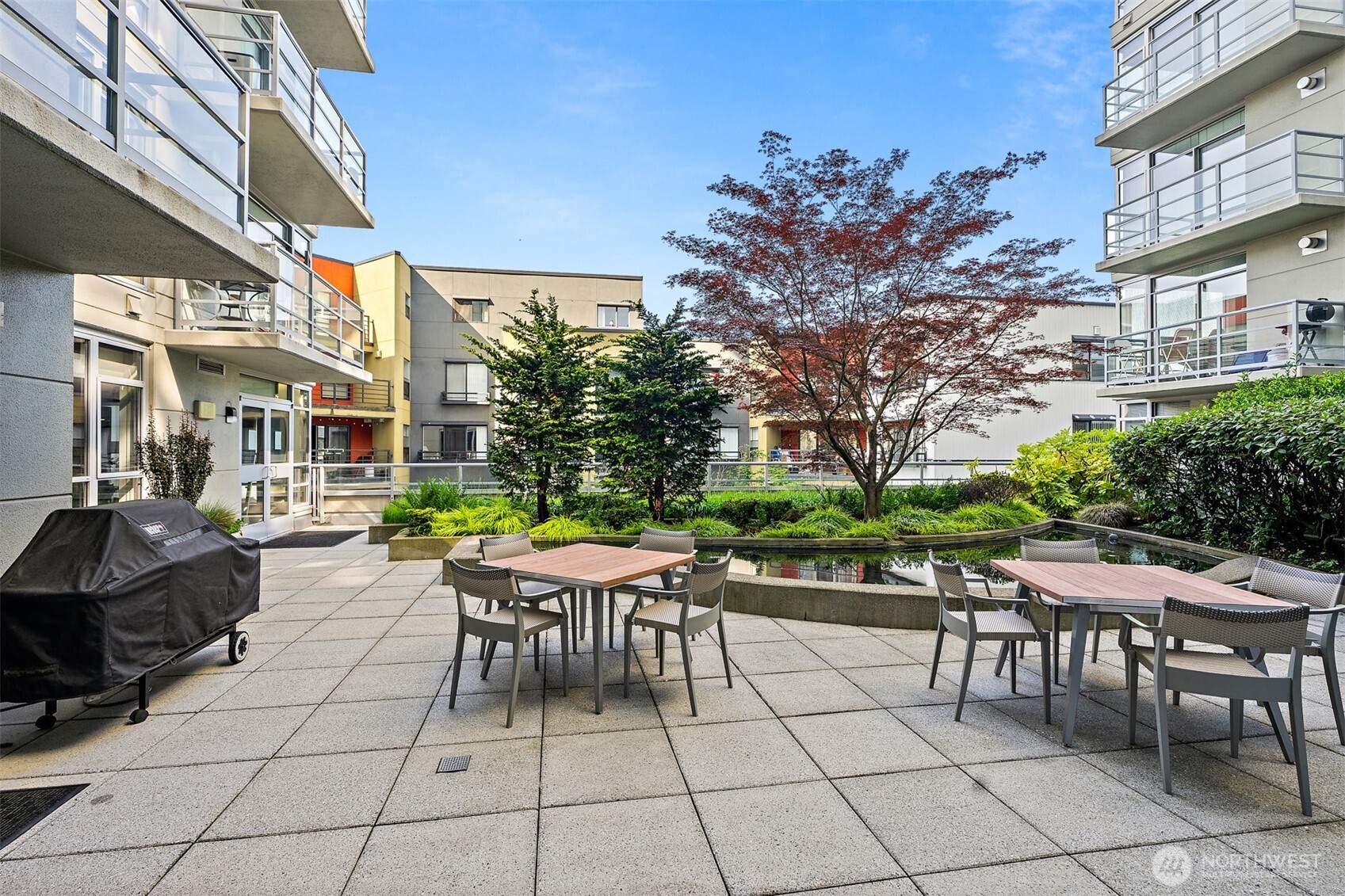 2929 1st Avenue, Unit 514 Seattle, WA 98121 - Photo 16 of 23 a view of a patio with table and chairs and potted plants