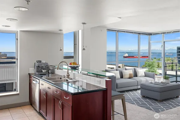 a kitchen with kitchen island granite countertop a sink and a stove