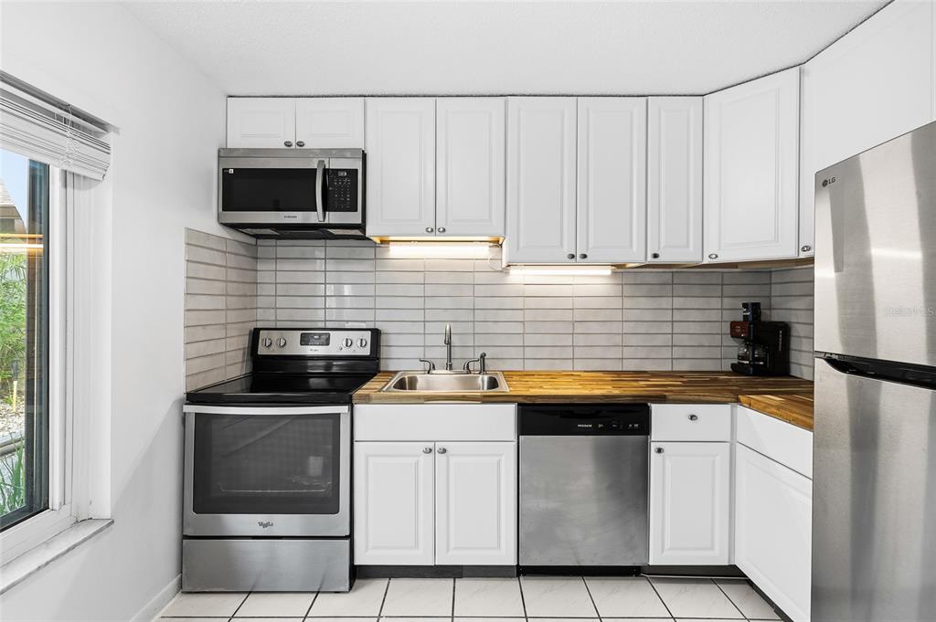 2209 Belleair Road, Unit C5 Clearwater, FL 33764 - Photo 12 of 30 a kitchen with white cabinets stainless steel appliances and sink