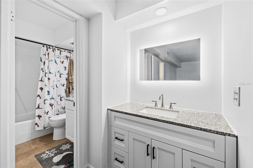 2209 Belleair Road, Unit C5 Clearwater, FL 33764 - Photo 15 of 30 a bathroom with a granite countertop sink a toilet and a mirror
