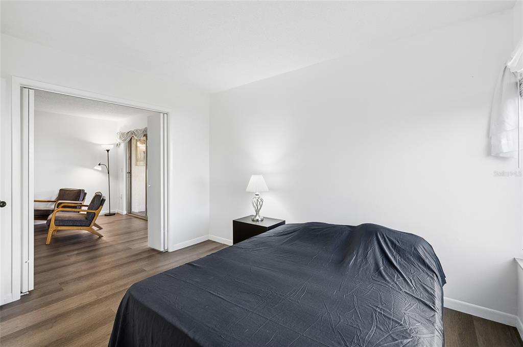 2209 Belleair Road, Unit C5 Clearwater, FL 33764 - Photo 20 of 30 a bedroom with a bed and wooden floor