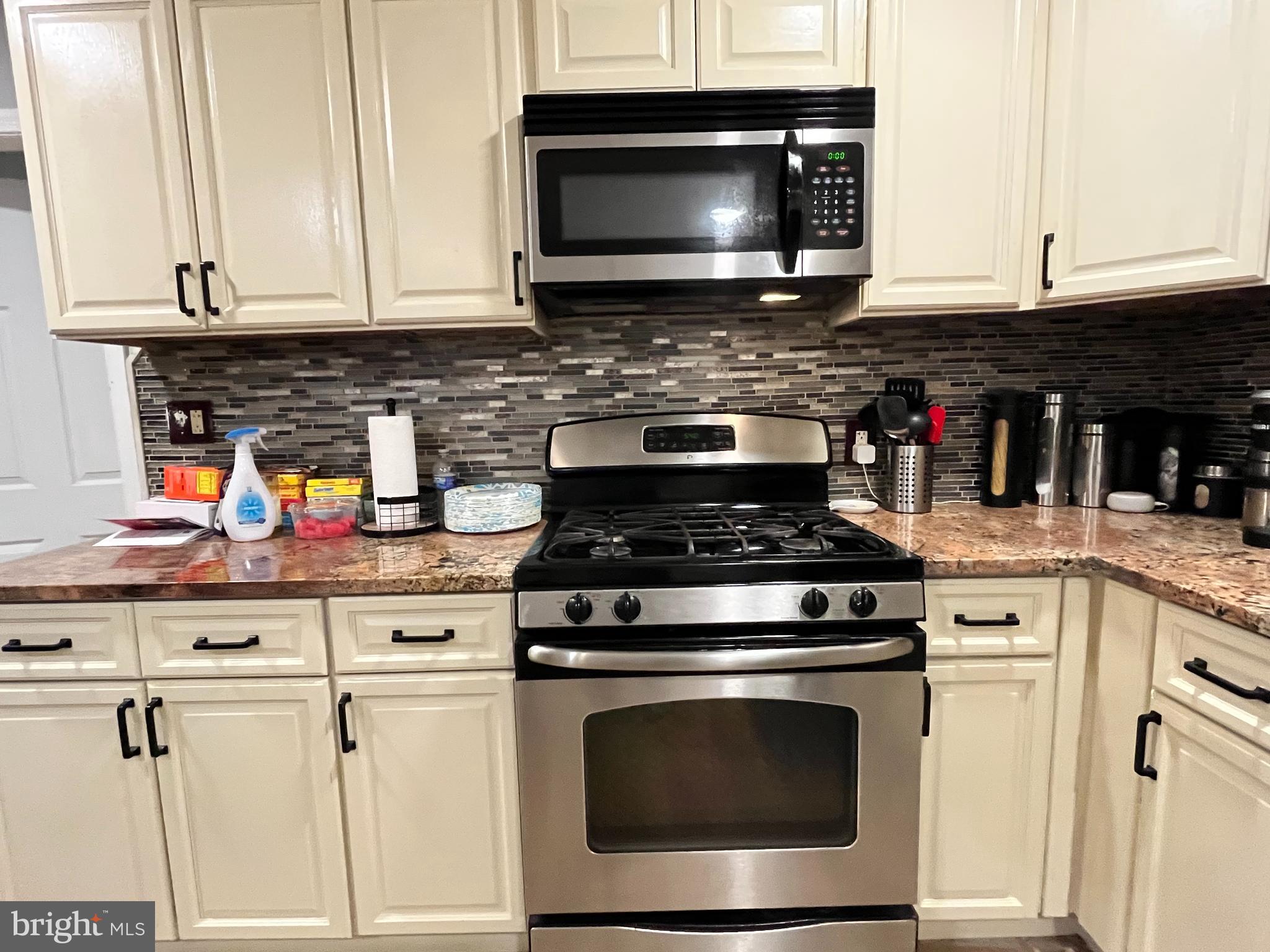 1304 Manor Road Lansdowne, PA 19050 - Photo 10 of 27 a kitchen with stainless steel appliances granite countertop a stove microwave and cabinets