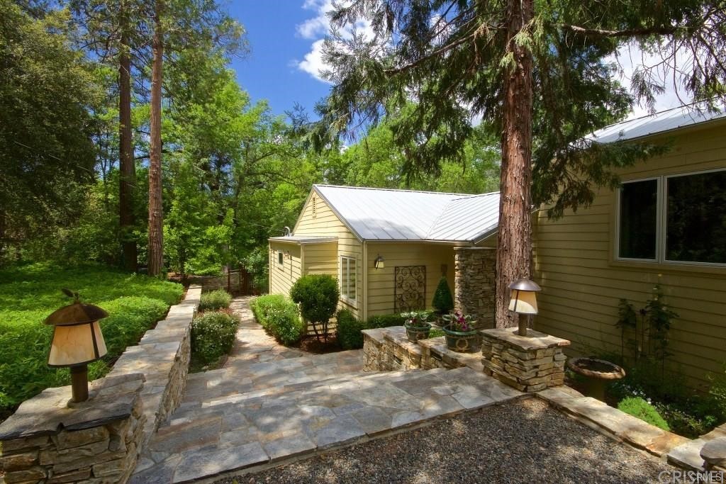 a view of a house with backyard garden and plants