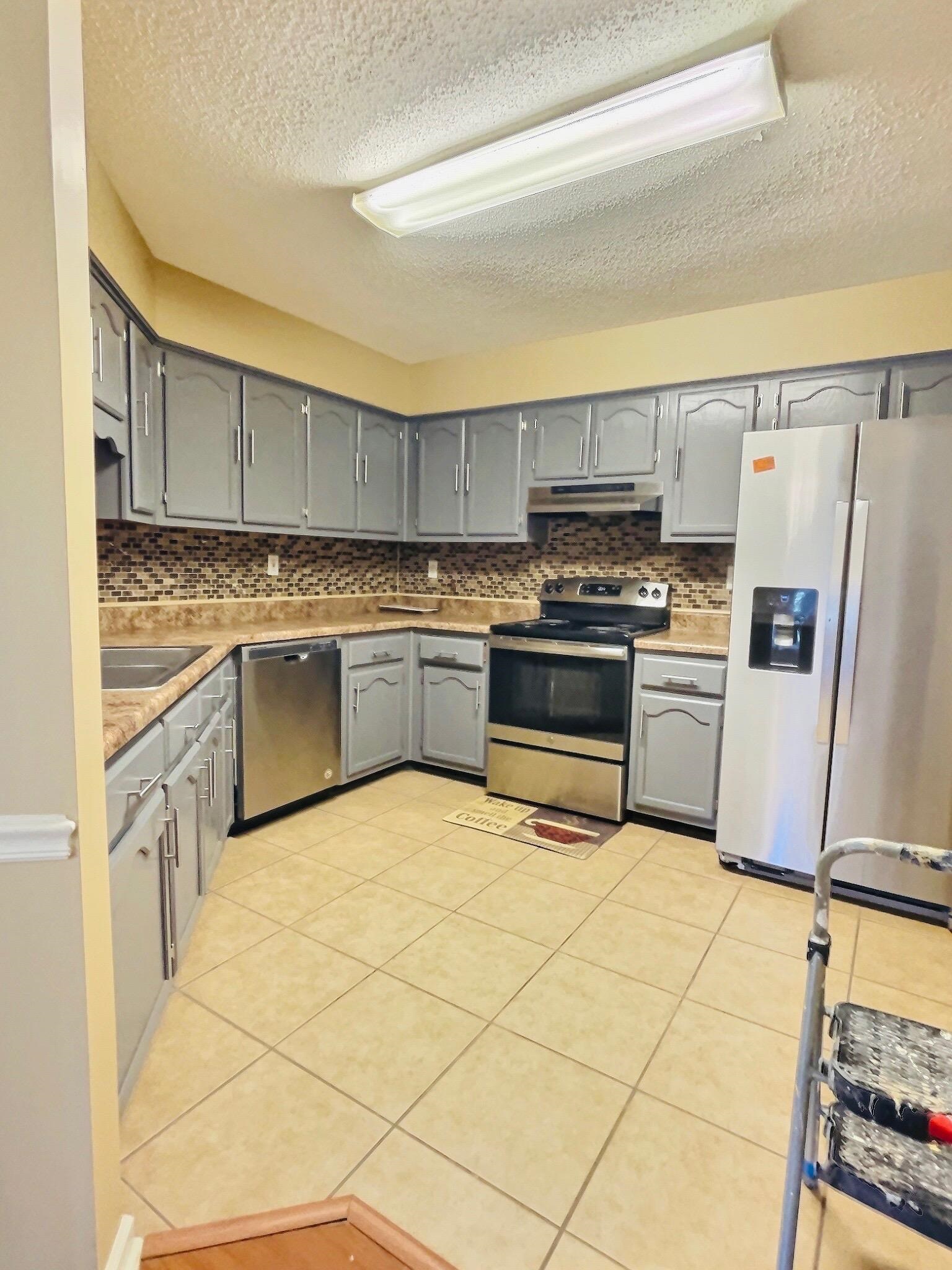 6946 Snyder Road Memphis, TN 38141 - Photo 3 of 12 a kitchen with stainless steel appliances granite countertop a stove a sink and a refrigerator