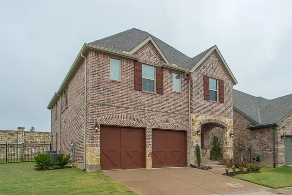 a front view of a house with a garden and garage