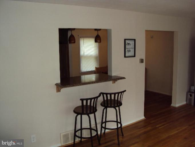 9006 Tammy Road Nottingham, MD 21236 - Photo 11 of 14 a view of a hallway with wooden floor and a cabinet